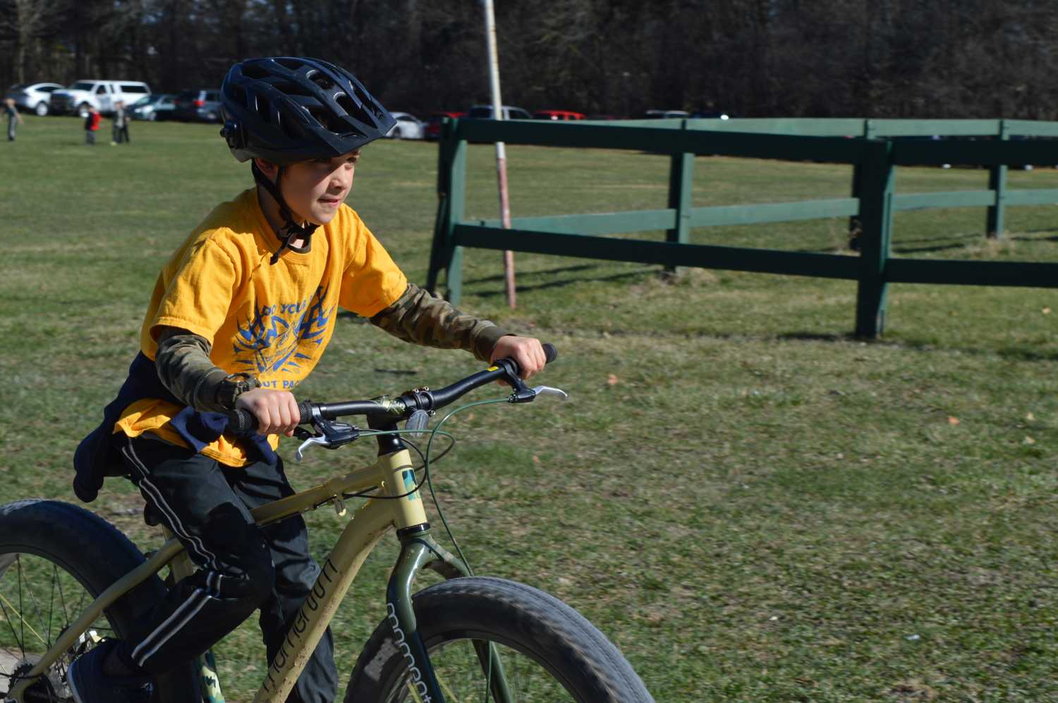 A scout rides a fat tire bike on the grass